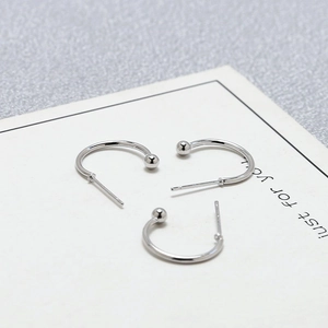 Polished silver C-shaped stud earrings with round bead ends on white card display