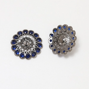 Macro view of gold-plated flower base with blue zircon and hollow filigree design