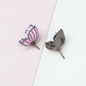 Detail of pink enamel butterfly earrings with gold plating and black metal backing