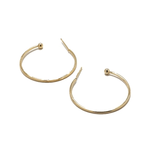 Minimalist gold-plated C-shaped hoop earrings with polished bead ends on white background
