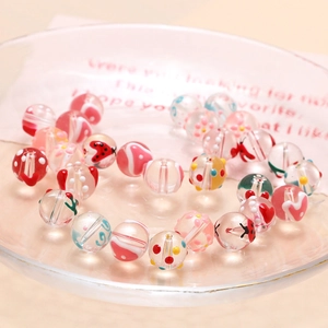 Makroaufnahme handbemalter bunter Glasperlen für DIY-Schmuck in einer Klarsichtschale