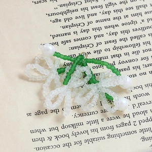 Dettaglio macro di ciondoli a fiore fatti a mano con perle verdi e perle sintetiche