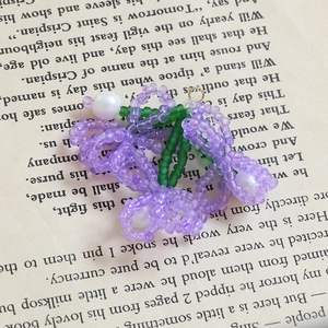 Dettaglio del ciondolo a fiore in rilievo fatto a mano con cristalli viola e perla