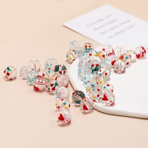 Detailaufnahme von DIY-Glasperlen mit handgemalten Kirschen und Herzen für Schmuck