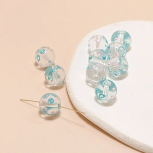 Makro-Detail von handgefertigten Glasperlen mit blauer Spirale und rosa Punkten für Schmuck