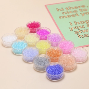 Detailed overhead view of 3mm frosted colorful seed beads set in 15 clear storage boxes