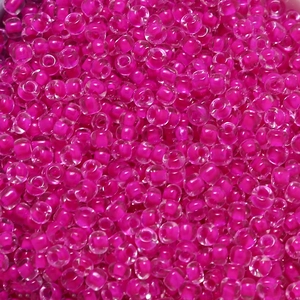 Macro detail of 4mm hot pink glass beads with dyed cores for DIY jewelry making