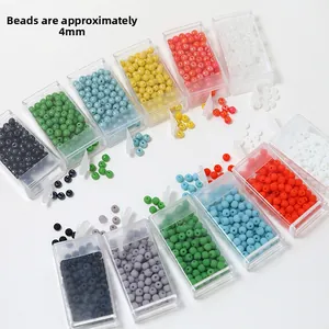 Primo piano di perline di vetro colorate da 4 mm in una scatola organizer trasparente
