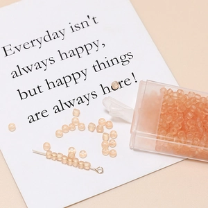 Macro view of 3mm matte orange seed beads for jewelry making with clear storage box