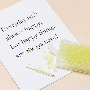 Detail of 3mm matte pale green seed beads in a plastic box for DIY jewelry making