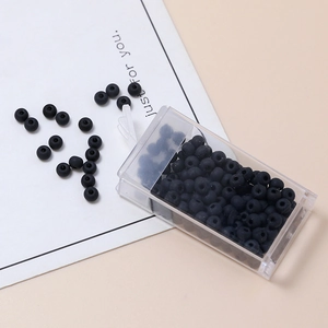 Macro di perline di vetro nero opaco da 4mm in un contenitore di plastica trasparente
