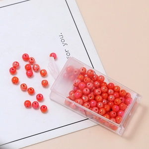 Dettaglio di perle smerigliate rosse e arancioni da 4mm in scatola per creazioni di gioielli