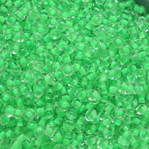 Macro view of 4mm vibrant transparent green glass seed beads for DIY jewelry making