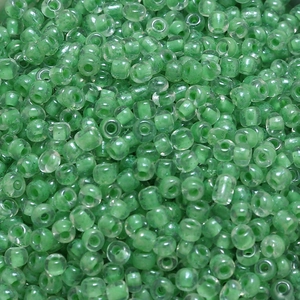 Macro detail of 4mm light green translucent glass seed beads with center hole for DIY jewelry