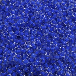 Macro detail of 4mm macaron blue glass seed beads with clear polished finish and core dyeing