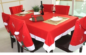 Close-up of red Christmas tablecloth and Santa hat chair covers with snowflake embroidery