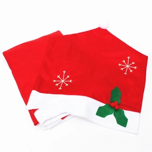 Detail of red Christmas hat chair cover with snowflake prints and holly berry accents