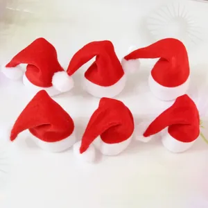 Détail de six mini bonnets de Noël rouges avec pompons blancs pour décor de bouteille