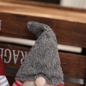 Close-up of a Christmas gnome doll featuring a gray plush hat and striped knit body