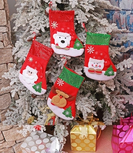 Detail of sequined Christmas stockings with Santa and reindeer on snowy tree branches