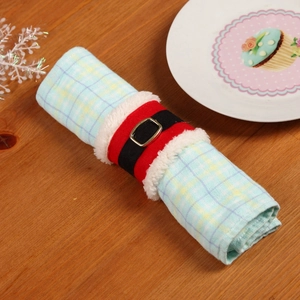 Dettaglio del portatovagliolo di Natale con design a cintura su un tavolo festivo