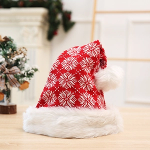 Détails du tricot du bonnet de Noël rouge avec motifs flocons et bordure en peluche blanche