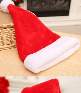 Detailed view of thick plush Christmas hat with white pom-pom on wooden table decor