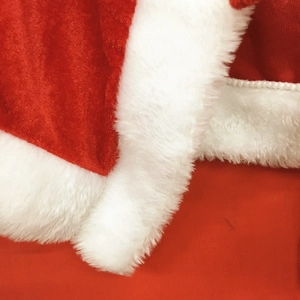 Close-up of red velvet Christmas cape with soft white faux fur trim and detailed texture