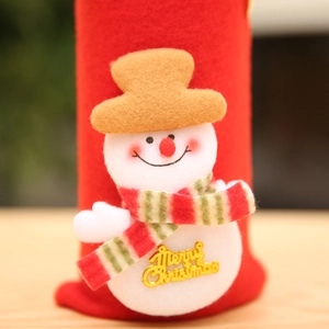 Detailed view of plush snowman and Merry Christmas text on a red wine bottle cover