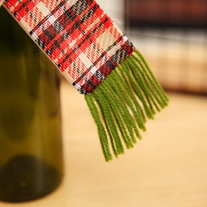 Detailansicht eines Mini-Weihnachtsschals mit Karomuster und grünen Fransen für Flaschen