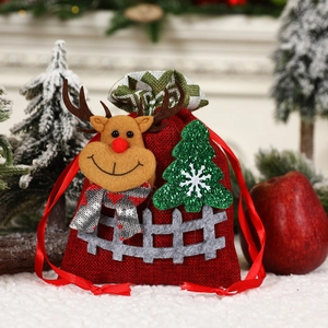 Detail of red burlap Christmas gift bag with 3D reindeer design and festive decorations