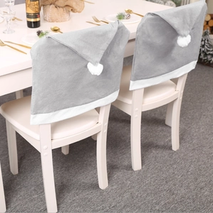 Grey plush Christmas chair back covers with white pom poms for festive dining decoration