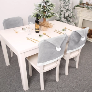 Set of 4 grey Santa hat chair covers with white pom-poms for Christmas dining decor