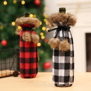 Detail of red and white plaid Christmas wine bottle covers with faux fur collars and pompoms