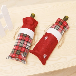 Christmas burlap wine bottle covers with red plaid and snowflake patterns on wooden table