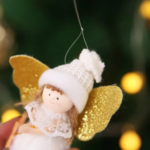 Close-up of white angel Christmas tree ornament with golden glitter wings and lace dress