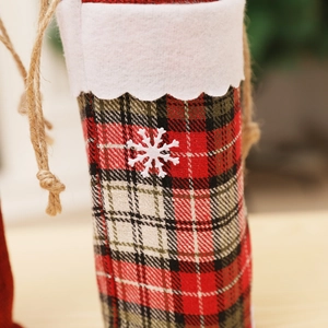 Detail of red and green plaid wine bottle bag with white snowflake and burlap drawstring