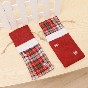 Detail of Christmas burlap wine bottle bags with festive snowflake patches and drawstrings