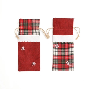 Detail of Christmas wine bottle covers featuring red green plaid and white snowflake embroidery