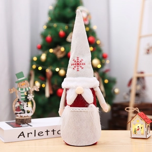 Close-up of Christmas gnome bottle cover with white snowflake hat and plush beard decor