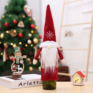 Detail of red Christmas gnome wine bottle cover with white snowflake pattern and beard