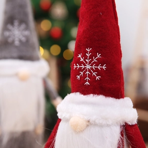 Detail of Christmas gnome bottle cover featuring delicate snowflake embroidery and plush beard