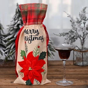 Close-up of burlap Christmas wine bag with plaid trim and 3D red poinsettia detail