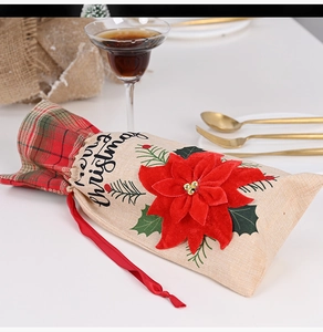 Detail of burlap Christmas wine bottle bag with Merry Christmas text and red velvet flower