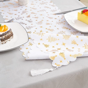 White Christmas table runner with gold foil tree patterns and elegant fringe tassels