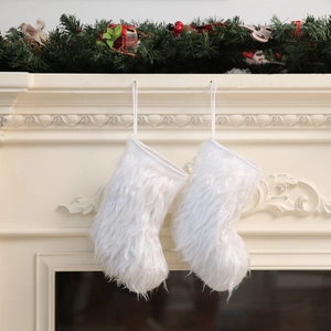 Detail of plush white faux fur Christmas stockings hanging from a classic white fireplace