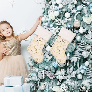 Christmas stockings with gold branch patterns and white plush trim on a tree