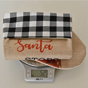 Calza di Natale a quadri con scritta Santa Stop Here, peso di 52,7 g sulla bilancia