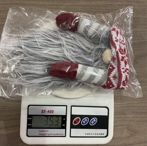 Detailed view of the 35.3g Christmas gnome wine bottle cover in protective packaging