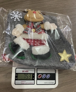 Detail view of a grey Christmas felt gift bag featuring a 3D reindeer doll on a scale